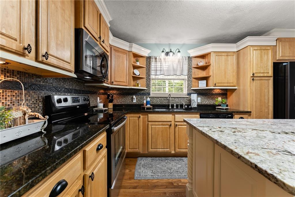 8958 Bill Savage Road Lula, GA 30554 - Photo 20 of 81 a kitchen with stainless steel appliances granite countertop a stove sink and cabinets