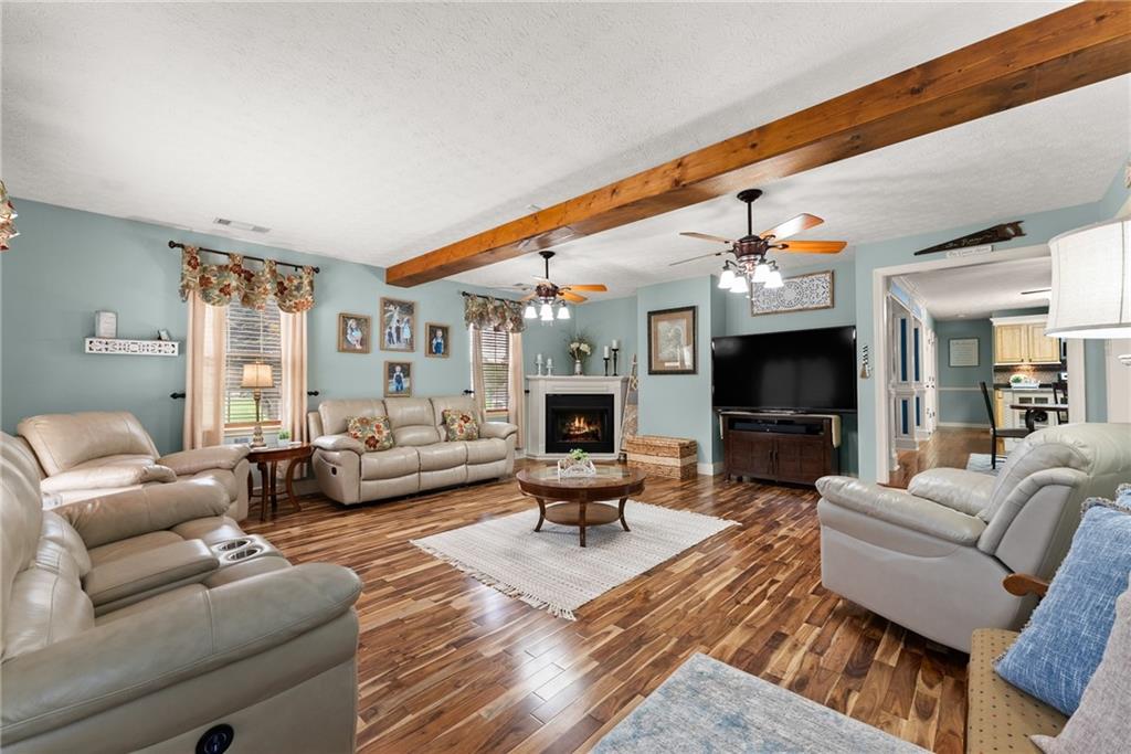 8958 Bill Savage Road Lula, GA 30554 - Photo 23 of 81 a living room with furniture a fireplace and a flat screen tv