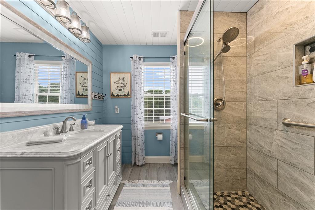 8958 Bill Savage Road Lula, GA 30554 - Photo 36 of 81 a bathroom with a double vanity sink a toilet and shower