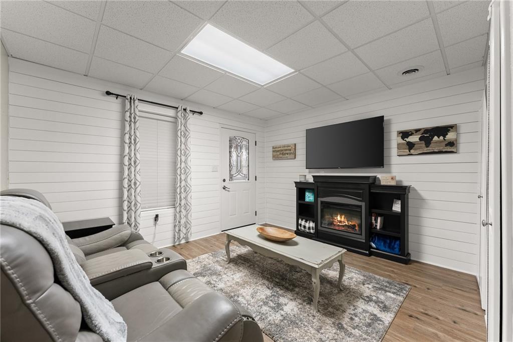 8958 Bill Savage Road Lula, GA 30554 - Photo 43 of 81 a living room with furniture a flat screen tv and a fireplace