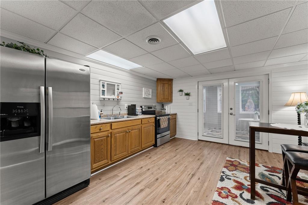 8958 Bill Savage Road Lula, GA 30554 - Photo 49 of 81 a large kitchen with stainless steel appliances kitchen island granite countertop a refrigerator a sink dishwasher a dining table and chairs with wooden floor