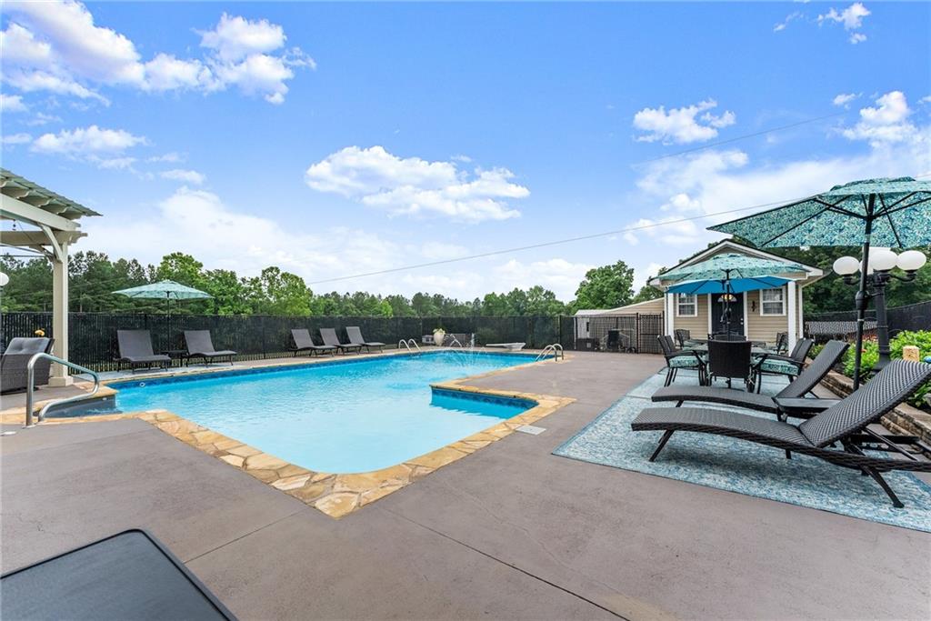 8958 Bill Savage Road Lula, GA 30554 - Photo 54 of 81 a view of a swimming pool with lounge chairs in patio