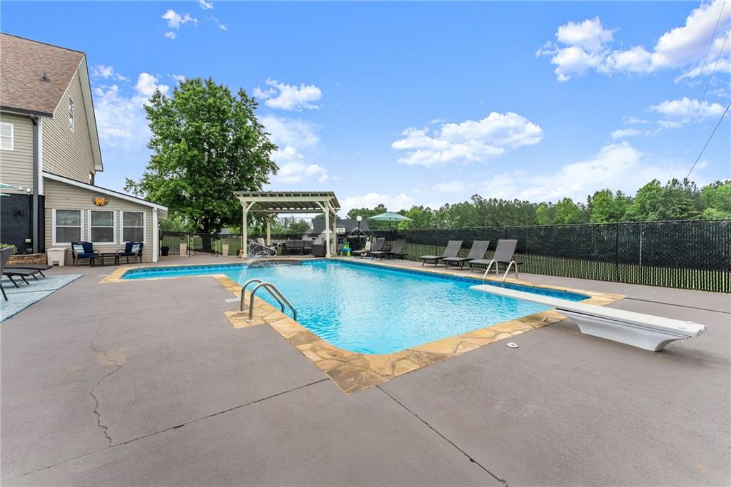 8958 Bill Savage Road Lula, GA 30554 - Photo 60 of 81 a view of a swimming pool with a chair and tables