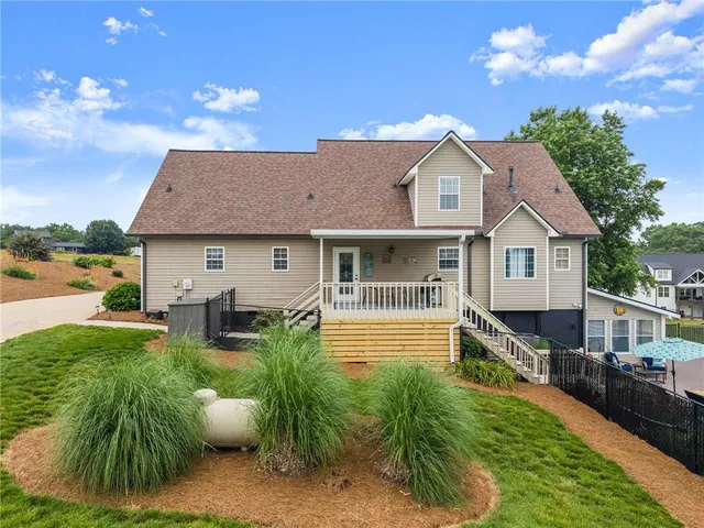 a view of a house with a yard and large tree