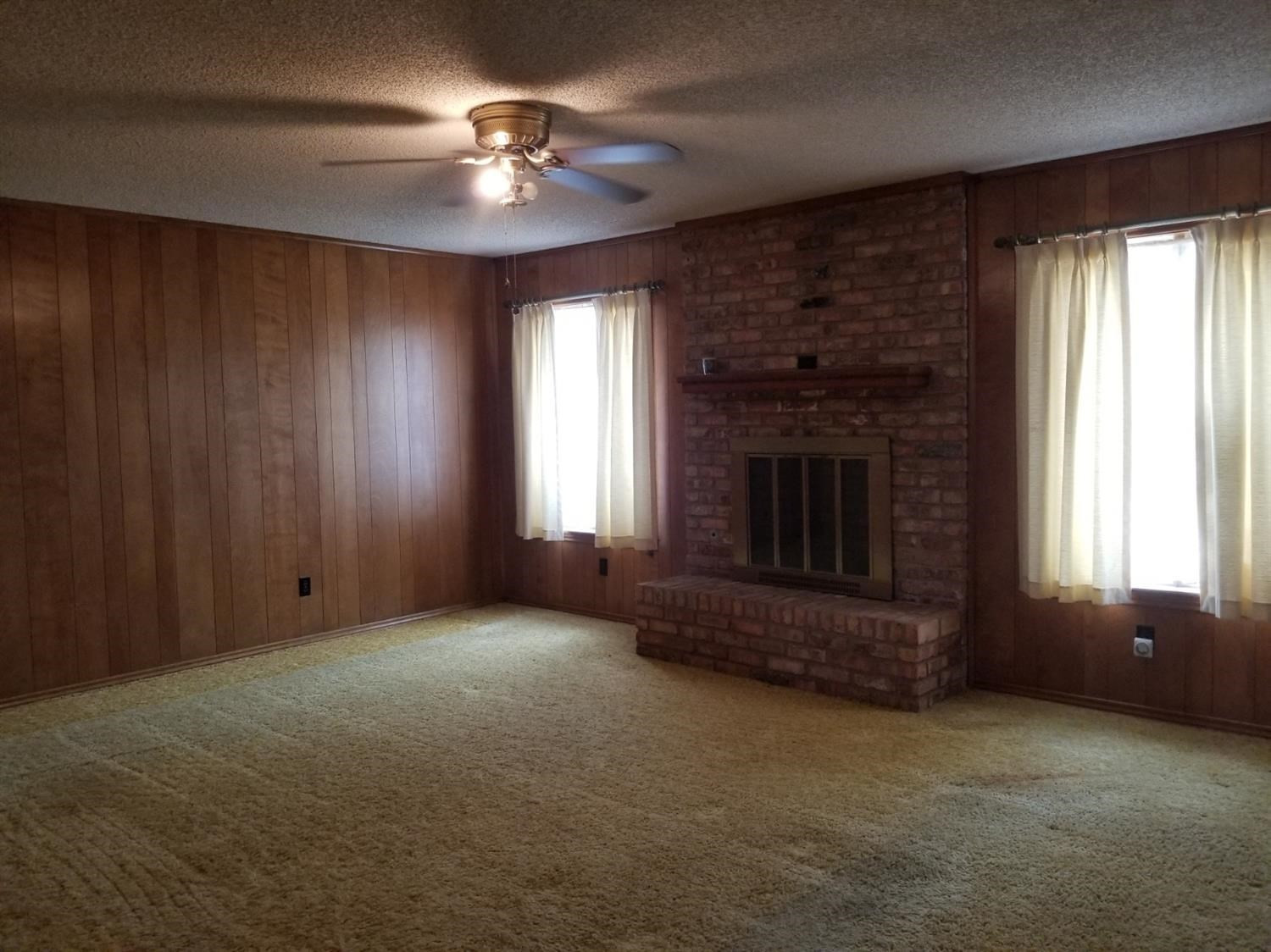 5314 22nd Street Lubbock, TX 79407 - Photo 6 of 10 an empty room with windows and fireplace