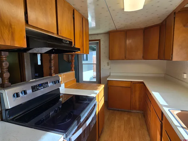 a kitchen with wooden cabinets and stove