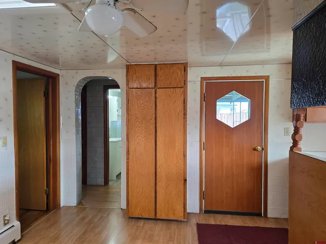 an empty room with wooden floor closet and windows