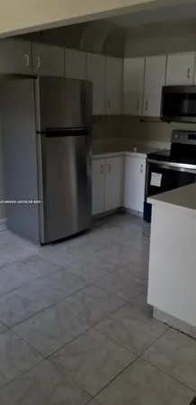 a kitchen with a refrigerator and cabinets