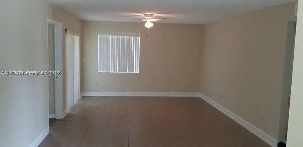 an empty room with windows and fan