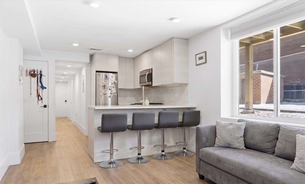 92 Chelsea Street, Unit 1 Boston, MA 02128 - Photo 1 of 14 a living room with kitchen island furniture and a window