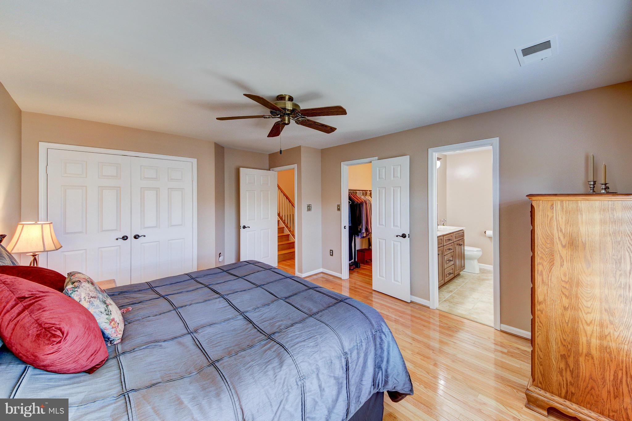 1258 Weatherstone Court Reston, VA 20194 - Photo 12 of 24 a spacious bedroom with a bed and a lamp