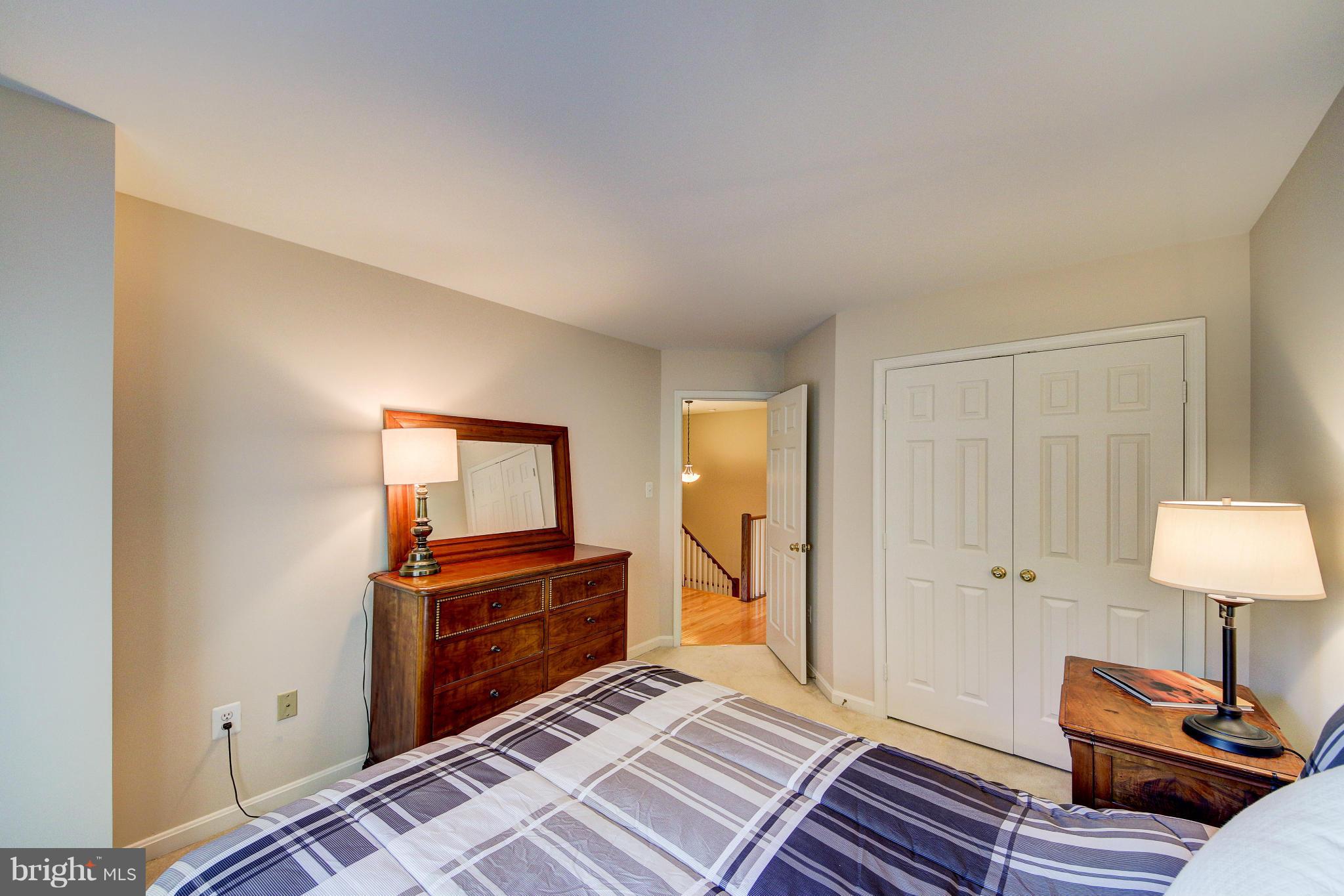 1258 Weatherstone Court Reston, VA 20194 - Photo 18 of 24 a bedroom with a bed and a lamp on table