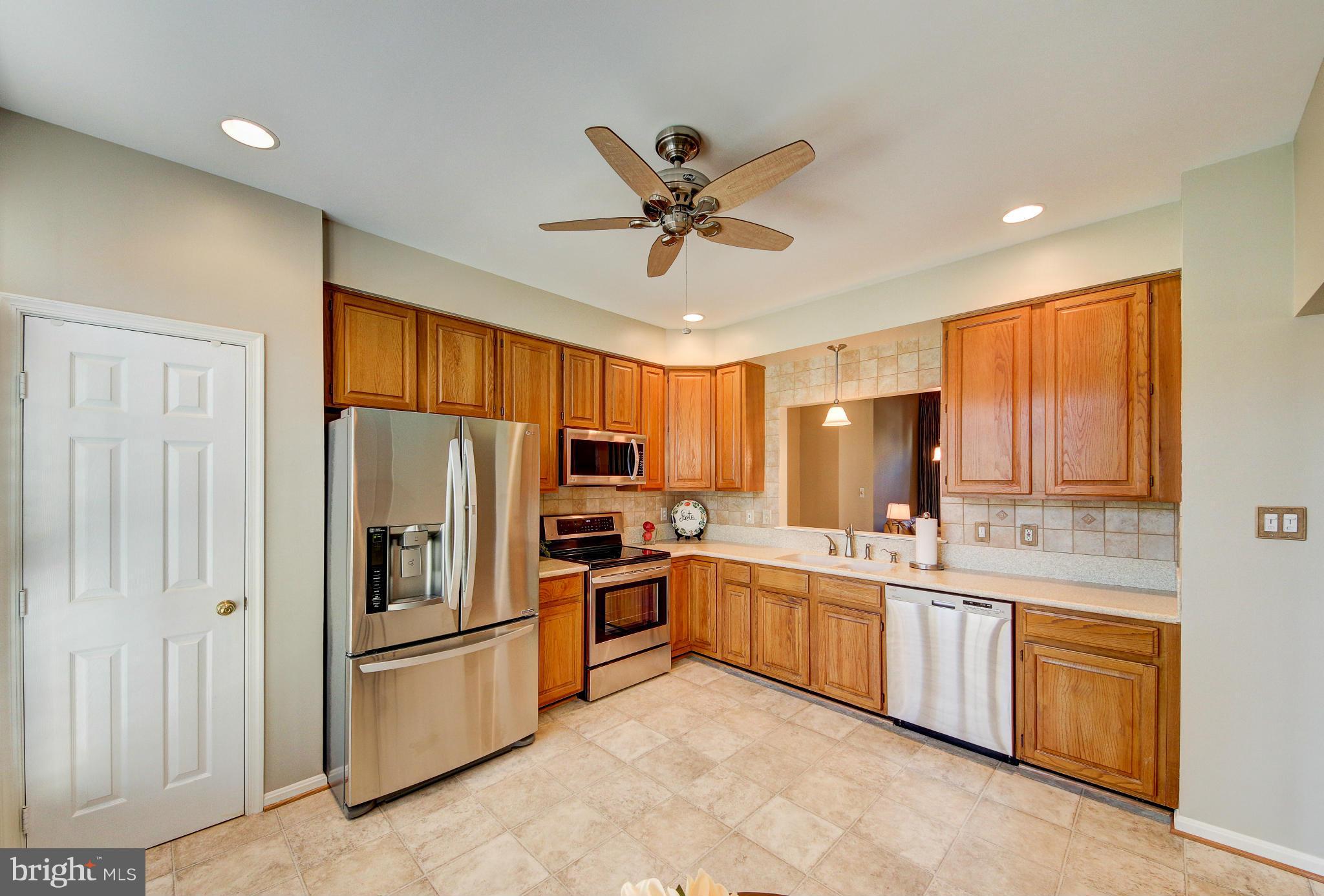 1258 Weatherstone Court Reston, VA 20194 - Photo 3 of 24 a kitchen with white cabinets and stainless steel appliances