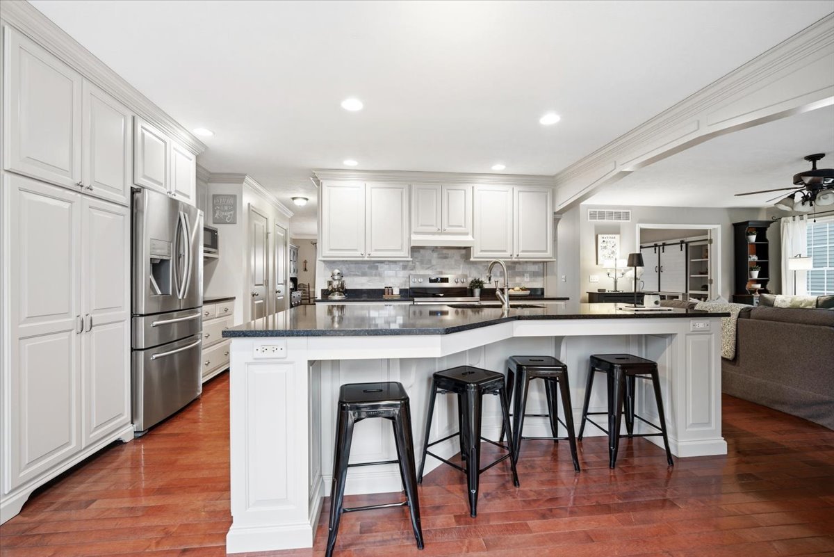1629 Cheyenne Lane Normal, IL 61761 - Photo 11 of 26 a kitchen with stainless steel appliances granite countertop a refrigerator a stove a sink a dining table and chairs with wooden floor