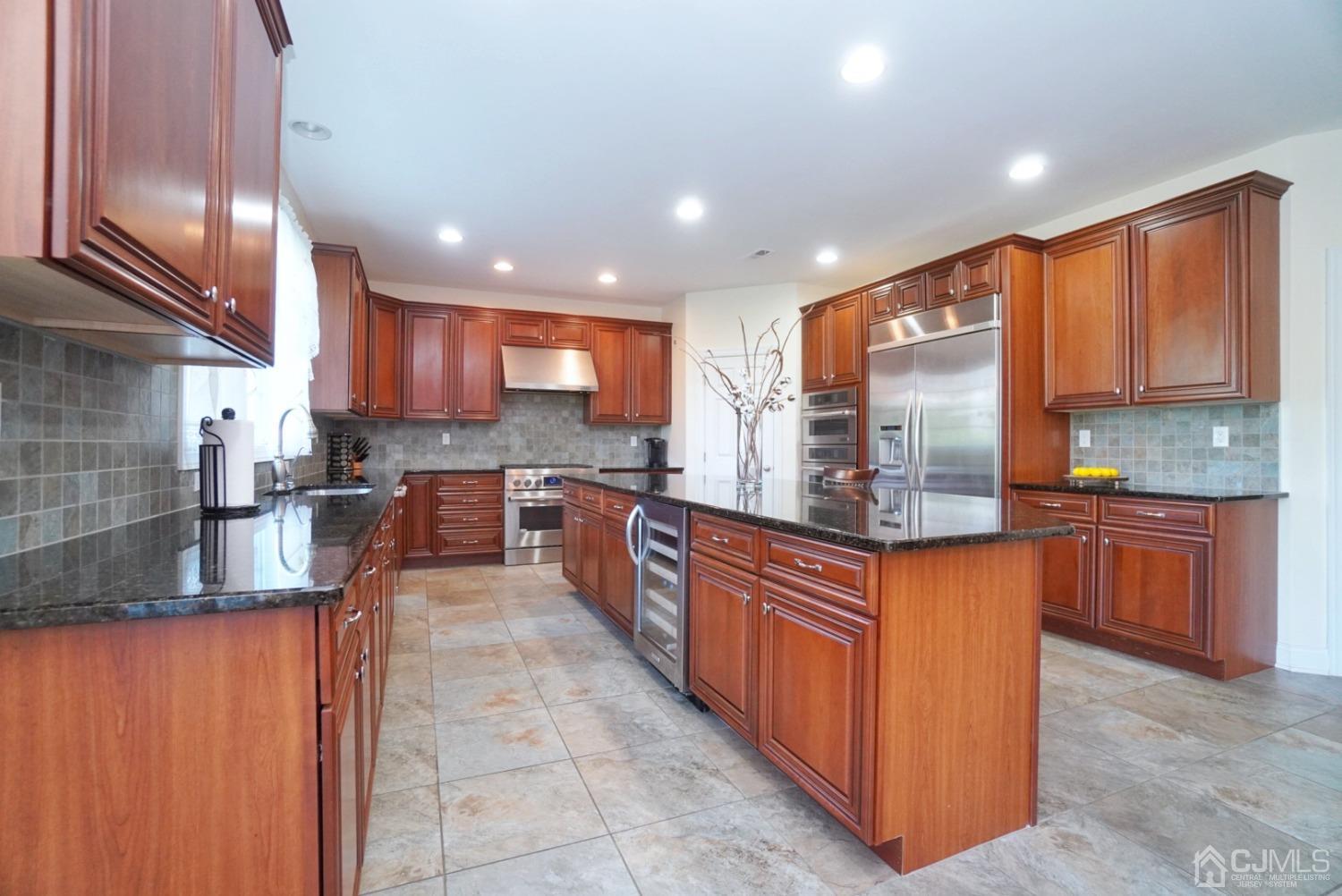 12 High Ridge Lane Augusta, NJ 07822 - Photo 18 of 49 a kitchen with stainless steel appliances granite countertop wooden cabinets a sink and a large window