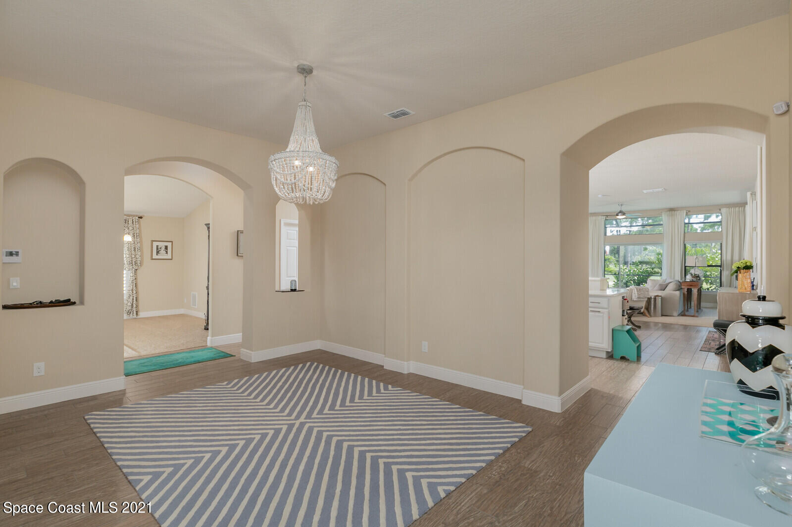 1398 Outrigger Circle Rockledge, FL 32955 - Photo 35 of 51 a room with lots of white furniture and a chandelier