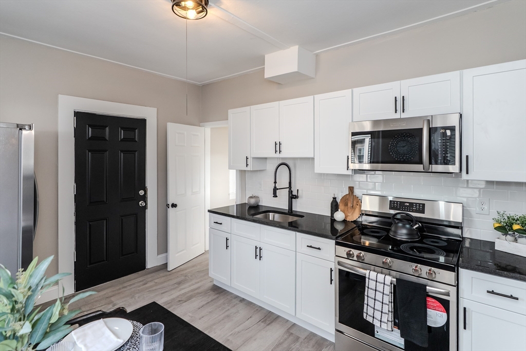 9 Ladd Street Springfield, MA 01109 - Photo 3 of 25 a kitchen with stainless steel appliances granite countertop a stove a sink and a microwave