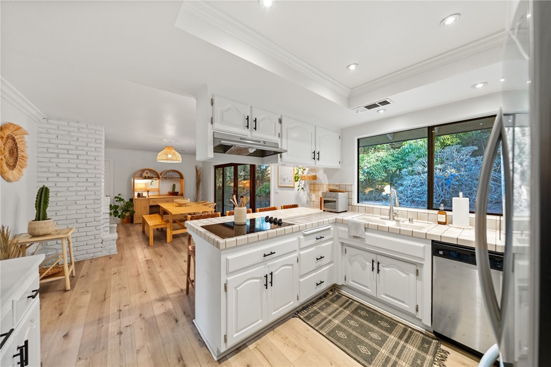 736 Del Valle Drive Fallbrook, CA 92028 - Photo 25 of 53 a open kitchen with stainless steel appliances granite countertop a stove top oven a sink dishwasher and white cabinets with wooden floor