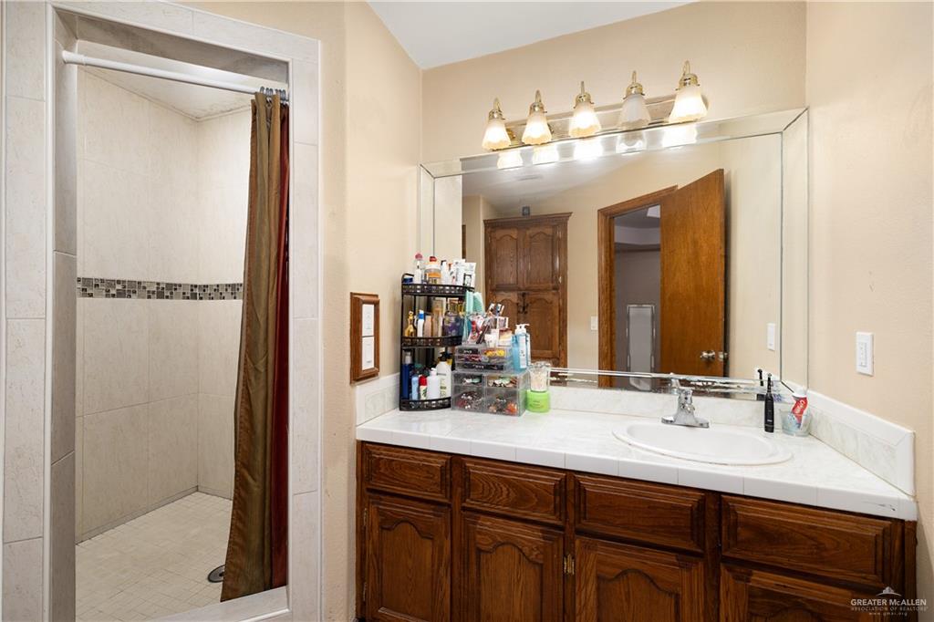 704 Goodwin Acres Road Mission, TX 78574 - Photo 11 of 26 a bathroom with a sink double vanity and a mirror