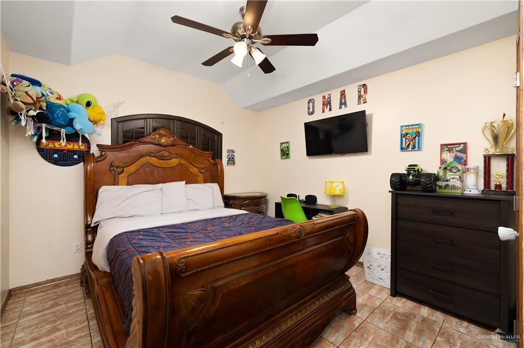 704 Goodwin Acres Road Mission, TX 78574 - Photo 12 of 26 a bedroom with a bed and flat screen tv