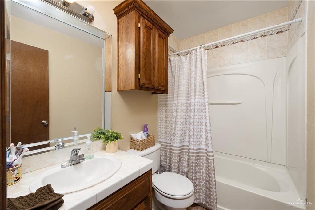 704 Goodwin Acres Road Mission, TX 78574 - Photo 13 of 26 a bathroom with a sink toilet and shower