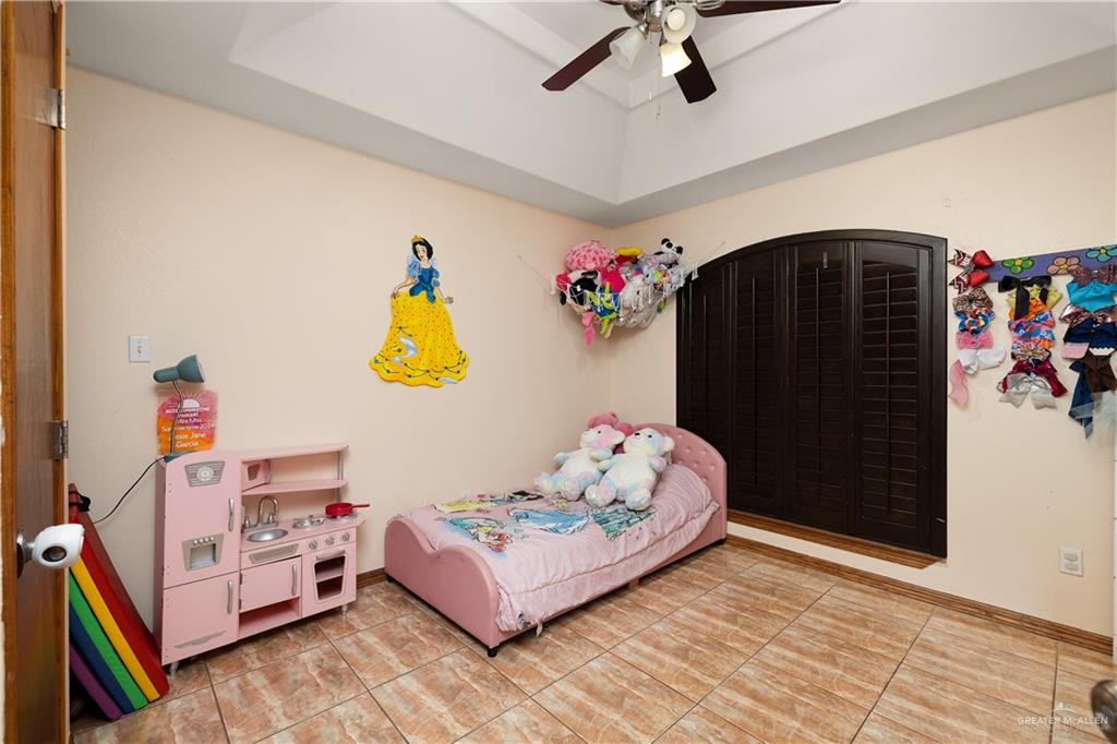 704 Goodwin Acres Road Mission, TX 78574 - Photo 14 of 26 a bedroom with furniture and a chandelier