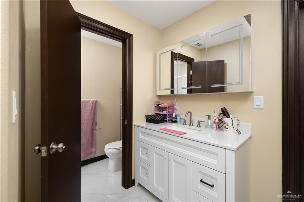 704 Goodwin Acres Road Mission, TX 78574 - Photo 16 of 26 a bathroom with a sink vanity and a toilet