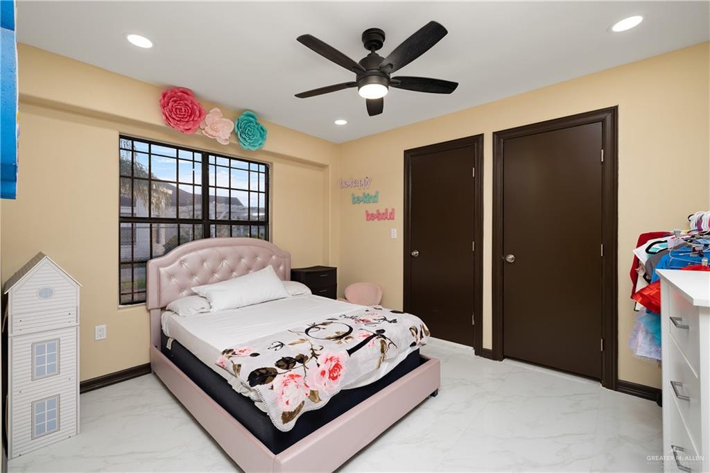 704 Goodwin Acres Road Mission, TX 78574 - Photo 17 of 26 a bedroom with a bed and a chandelier
