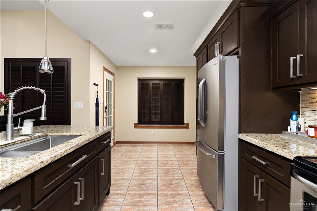 704 Goodwin Acres Road Mission, TX 78574 - Photo 9 of 26 a kitchen with granite countertop a refrigerator and a sink