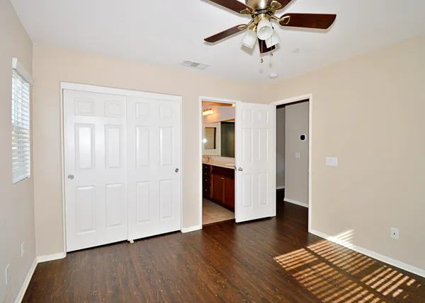 a view of an empty room with window and wooden floor