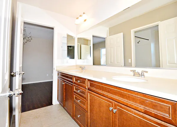 a spacious bathroom with double vanity and a mirror