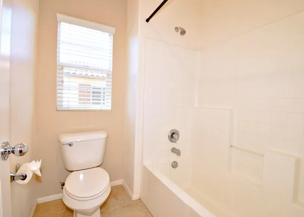 a white toilet sitting next to a bath tub
