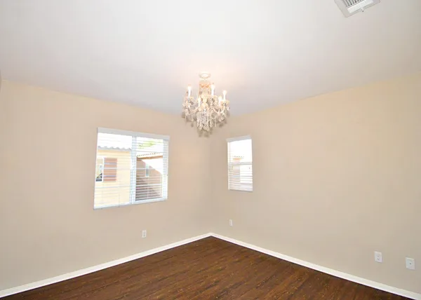 a view of a room with wooden floor and chandelier