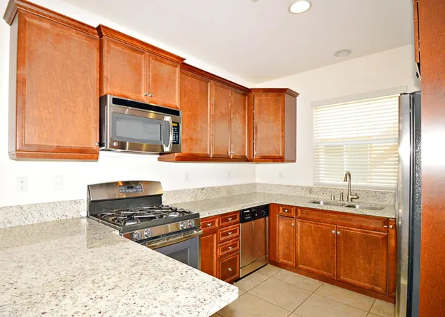 a kitchen with a sink stove top oven and cabinets