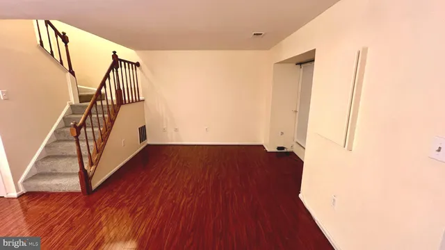 a view of front door with wooden floor and stairs