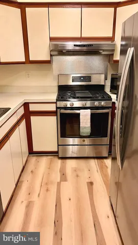 a stove top oven sitting inside of a kitchen