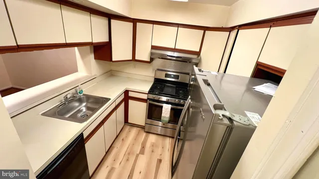 a view of a kitchen with a sink and wooden floor