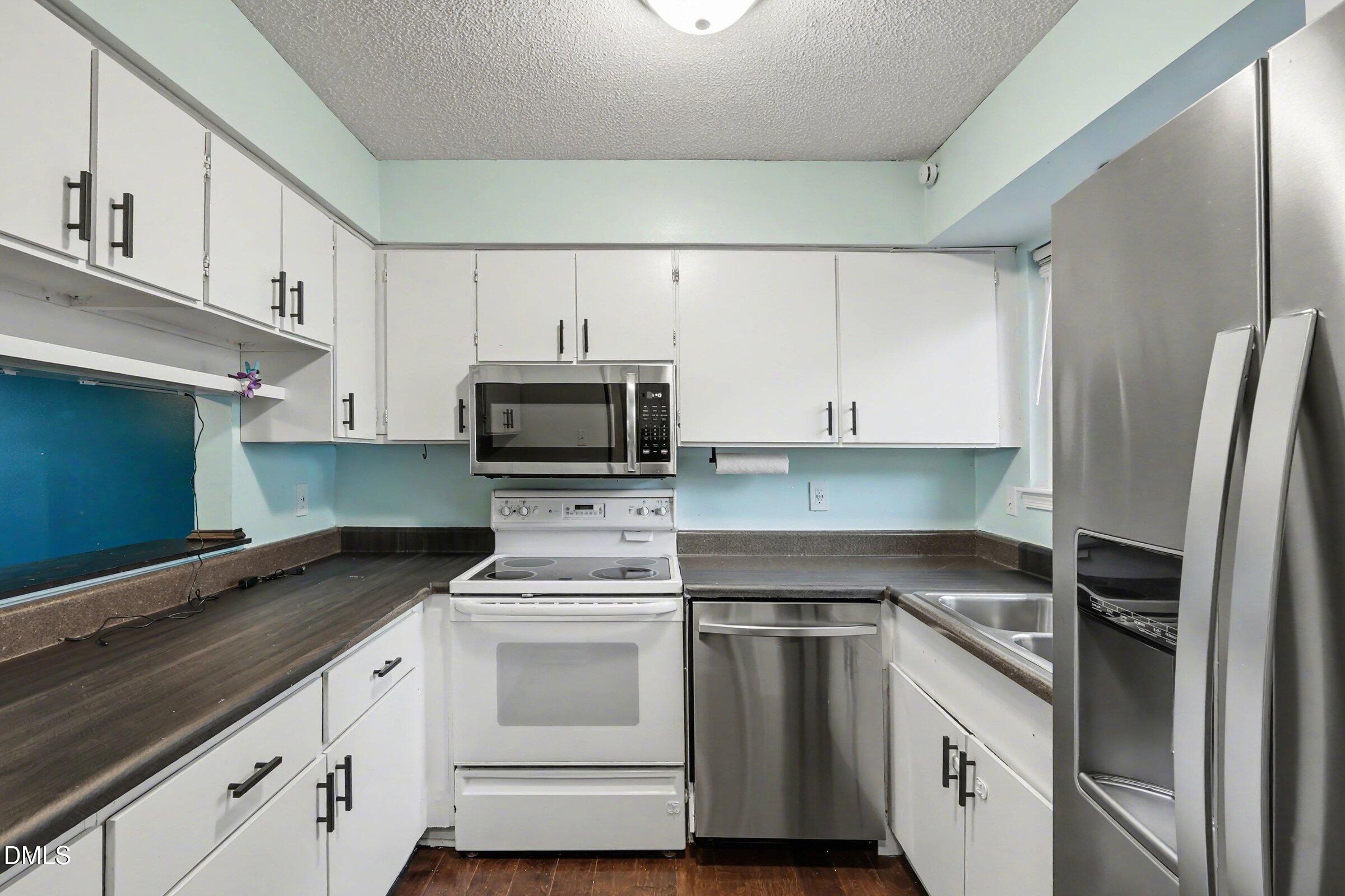 4271 Lake Ridge Drive Raleigh, NC 27604 - Photo 16 of 36 a kitchen with white cabinets and white appliances