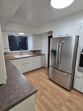 a kitchen with granite countertop a refrigerator and a sink