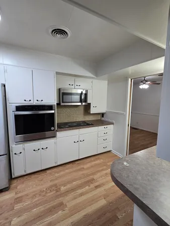 a kitchen with stainless steel appliances a refrigerator sink and white cabinets
