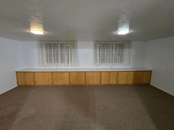 en empty room with windows and fan