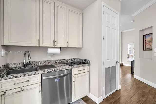 a kitchen with granite countertop white cabinets and sink