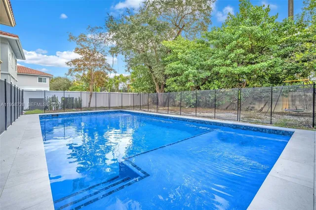 a view of a backyard with table and chairs and wooden fence