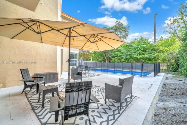 a view of an outdoor sitting area with couch and umbrella