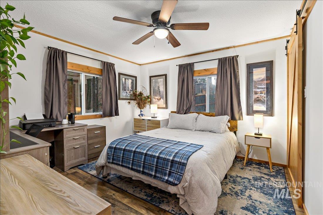 79 Sunset Loop Cascade, ID 83611 - Photo 30 of 44 Bedroom featuring wood-finish flooring, white walls with wood trim, and a ceiling fan with light