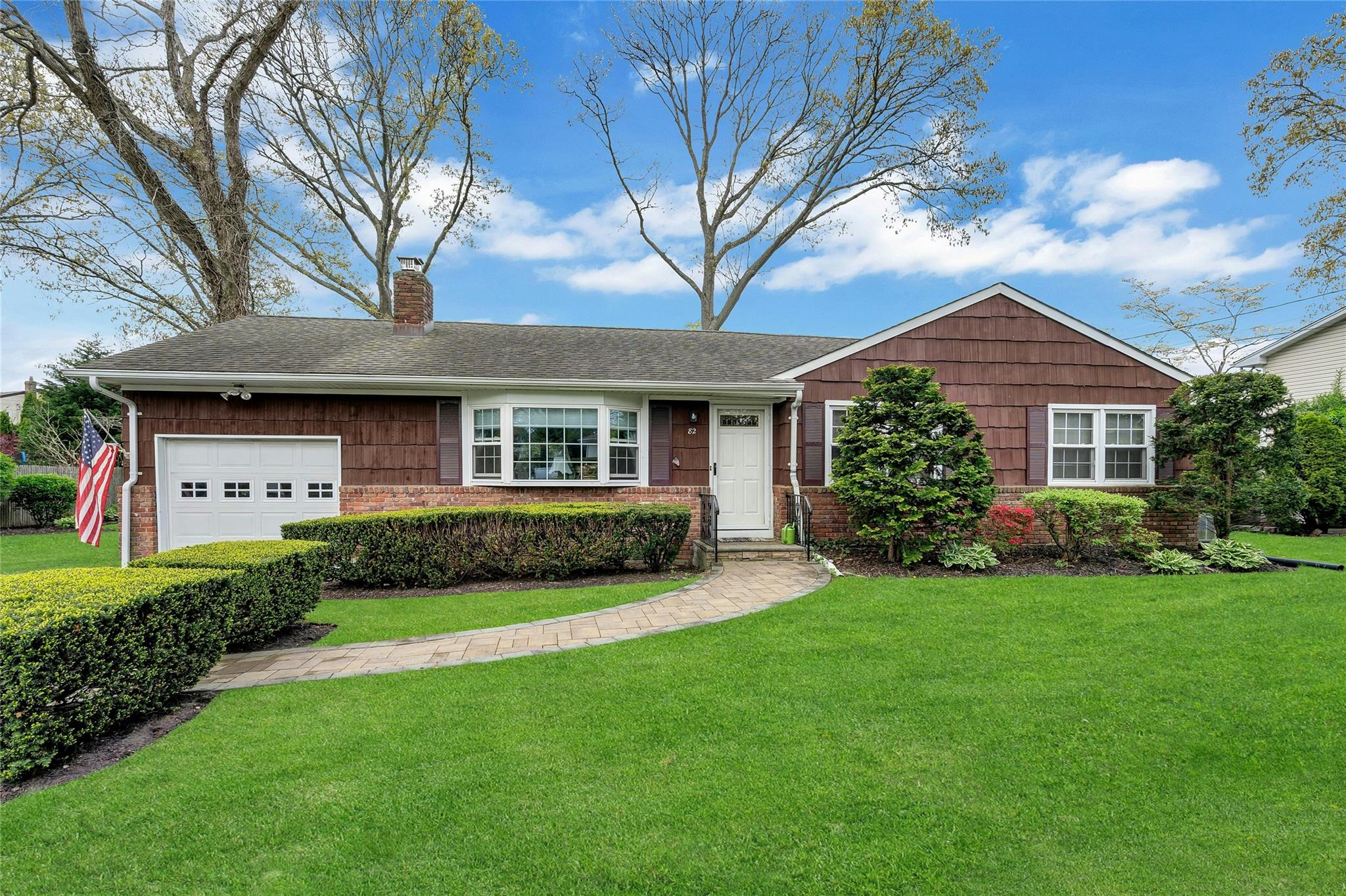 82 Lillian Road Nesconset, NY 11767 - Photo 1 of 1 Ranch-style home featuring an attached garage, a chimney, a front lawn, and brick siding
