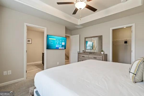 a bedroom with a large bed and a chandelier