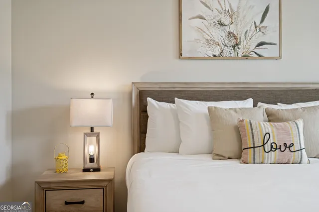 a bed with a white comforter and pillows