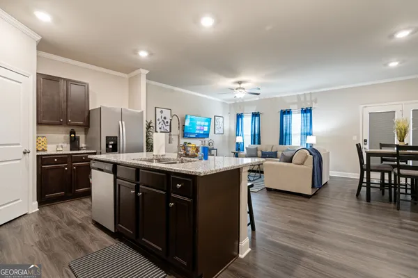 a large kitchen with stainless steel appliances a lot of counter space and wooden floor