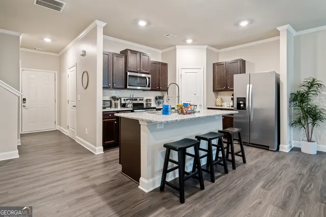 a kitchen with stainless steel appliances a refrigerator stove microwave and cabinets